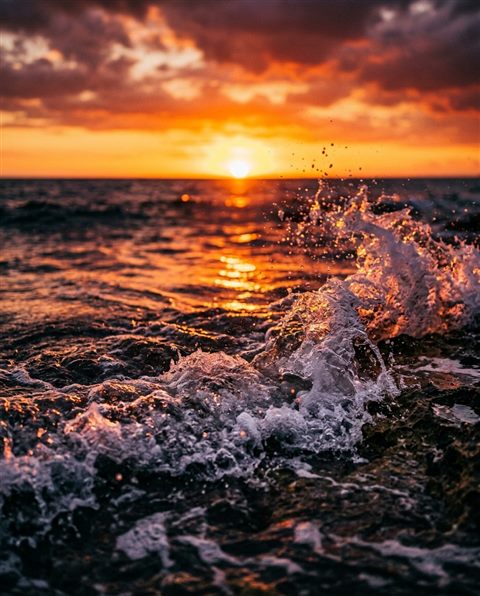 Cinematic film still of sunset over the sea, close-up detail with shallow depth of field, vivid colors, high contrast, energetic, 4:5 aspect ratio